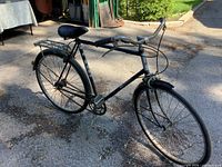Full left side view of bicycle with rack, fenders, kickstand visible