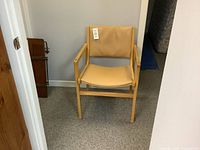 Front view of a tan vinyl beech armchair