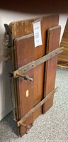 Front view folded press showing wood panels and metal clamp bars
