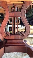 Lyre pedestal showing carved scrolls and vertical rods
