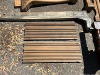 Three wood molding sections including long grey fluted piece and two brown profiles