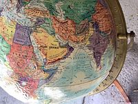 Close-up of globe showing Africa, Middle East, brass-tone meridian