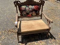 Full view of wooden settee bench showing arms, carved back, plank seat