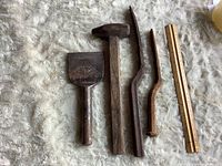 Top view of four vintage hand tools laid out next to ruler for scale