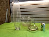 Group shot of three clear glass vases with soda can for scale