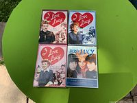 Front covers of four DVD box sets on green surface