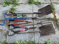 All eight garden tools laid out on patio