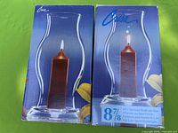 Front view of both boxed Crisa hurricane candle holders