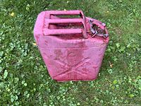 Front view of red jerry can showing G and QMC markings and condition