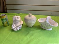 Group shot: ceramic vase, plaster head plaque, ceramic basket; soda can for scale