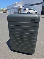 Front view of Away dark green carry-on suitcase