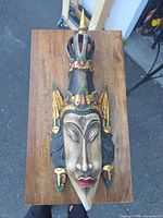 Full view of carved wood wall mask on tabletop