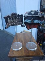 Both embroidered Chinese child headdresses on clear stands