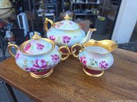Front view of complete three-piece tea set on table