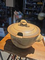 angled view of casserole with lid showing exterior swirl, handle and ladle notch