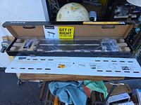 Open box showing Sanus wall mount, foam protection, instruction template and hardware