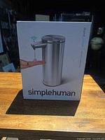 Front of boxed simplehuman sensor soap dispenser