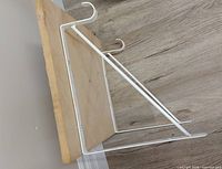 Shelf board with attached white metal brackets side view