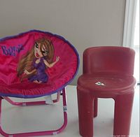 Bratz saucer chair beside red plastic chair on table
