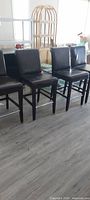 Front view of four brown leather bar chairs aligned