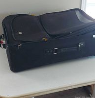 Closed black suitcase on table showing top and side
