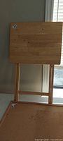 Front view of folding snack table standing upright