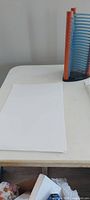 Paper sheets on table beside CD/DVD rack