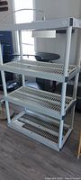Full view of shelving showing four slatted shelves and light fixture