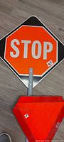 Close-up of STOP sign on pole, sticker visible