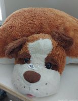 Large brown and white plush dog pillow