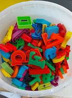 Bucket with multicolour plastic alphabet and number magnets