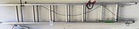 Full view of aluminum extension ladder hung on wall