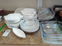 Group shot showing CorningWare casseroles, glass pie plates, square Pyrex bakers, aluminum pans