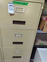 Front view showing upper drawers, beige metal finish, label holder, handle