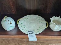Front view of three Belleek shamrock pieces on shelf