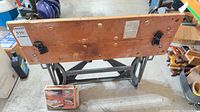 Front view of workbench showing laminated top, dog holes, bench dogs, boxed Gripmate accessory
