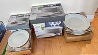 Boxed Canvas stoneware plates and stacks of loose plates