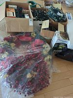 Overall lot showing tree stand, boxes with light strings on spools, loose lights, bagged wreath/garland