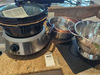 Group shot showing slow cooker, colander, pot, and steamer insert
