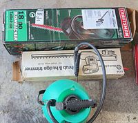 Top view showing Craftsman 18 in trimmer box, 13 in multi-tool box, and green pump sprayer
