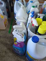 Wide view showing multiple Clorox jugs, Tilex sprays, Lysol cans in bucket