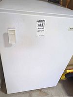Front view of Kenmore upright freezer with handle and badge