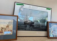 All three framed artworks leaning against wall
