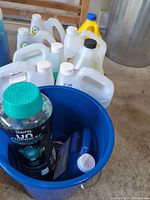Group of containers and Downy bottle in blue bucket