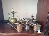 Group view of six brass and copper decorative vessels