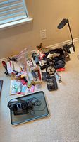 Group shot of headphones, lamp, hardware, office supplies spread on floor