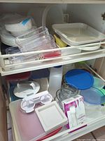 Drawer with multiple plastic containers, trays, glass bowls and disposable cutlery