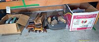 overview of lot showing boxes with power tool, hand saws, sanding accessories