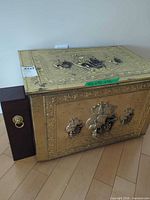 Front and top view of hammered brass trunk and adjacent wooden box