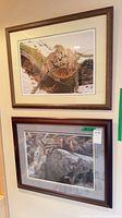 Both framed prints hung on wall